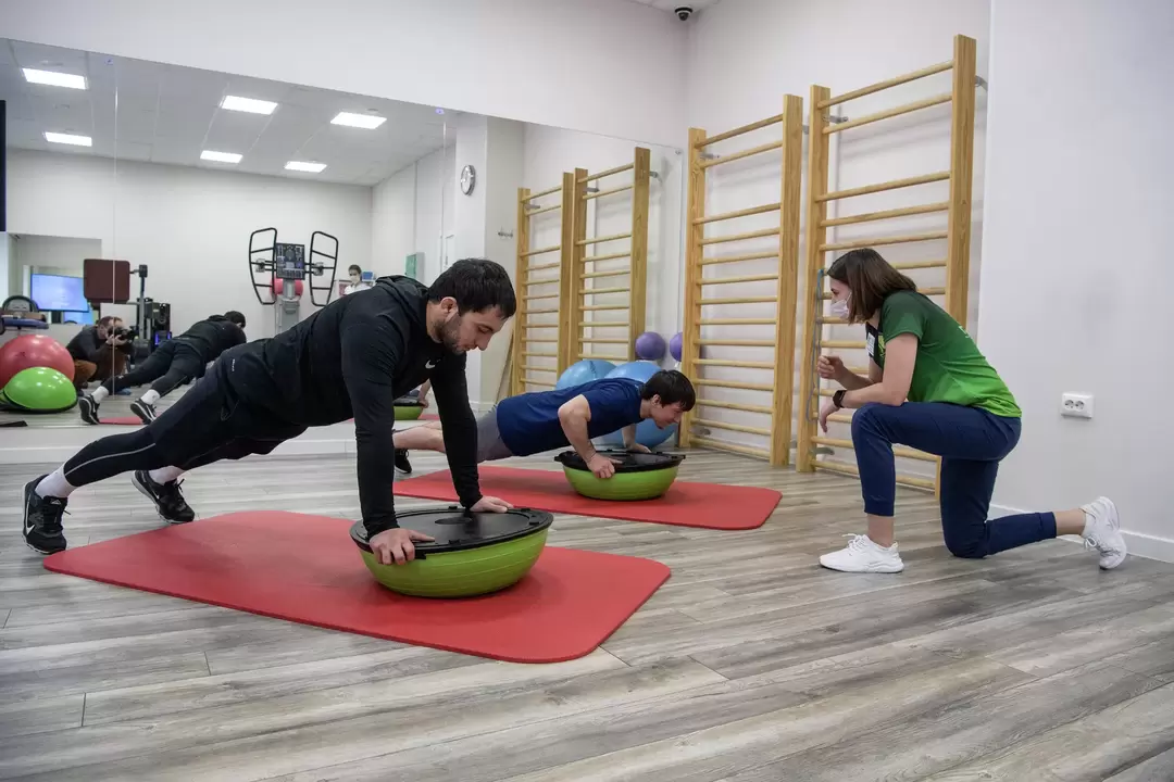 Rehabilitation therapist teaches exercise therapy classes to patients suffering from lower back pain